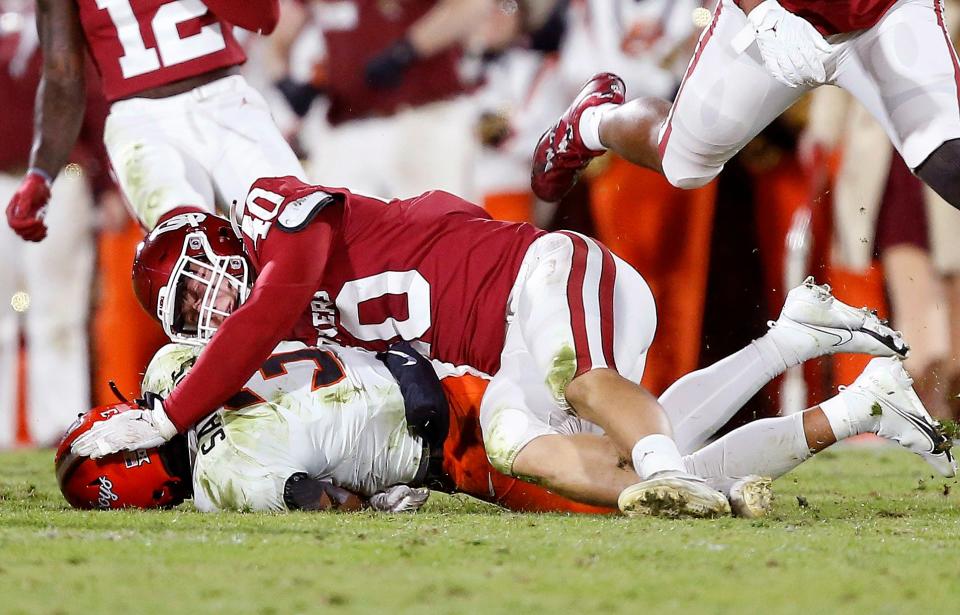 Oklahoma's Ethan Downs (40) tackles Spencer Sanders (3) in the first half during the Bedlam college football game between the University of Oklahoma Sooners (OU) and the Oklahoma State University Cowboys (OSU) at Gaylord Family-Oklahoma Memorial Stadium, in Norman, Okla., Saturday, Nov., 19, 2022. 