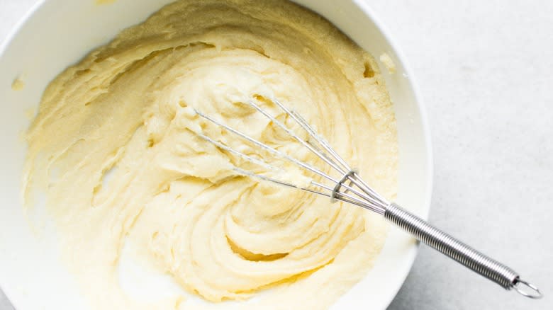 Top-down view of creamed butter and sugar in a bowl with a whisk
