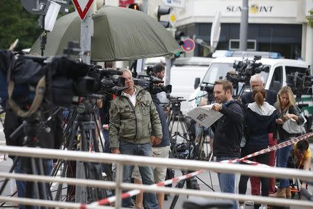 Journalists gather near the Olympia shopping mall, where yesterday's shooting rampage started, in Munich, Germany July 23, 2016. REUTERS/Michael Dalder