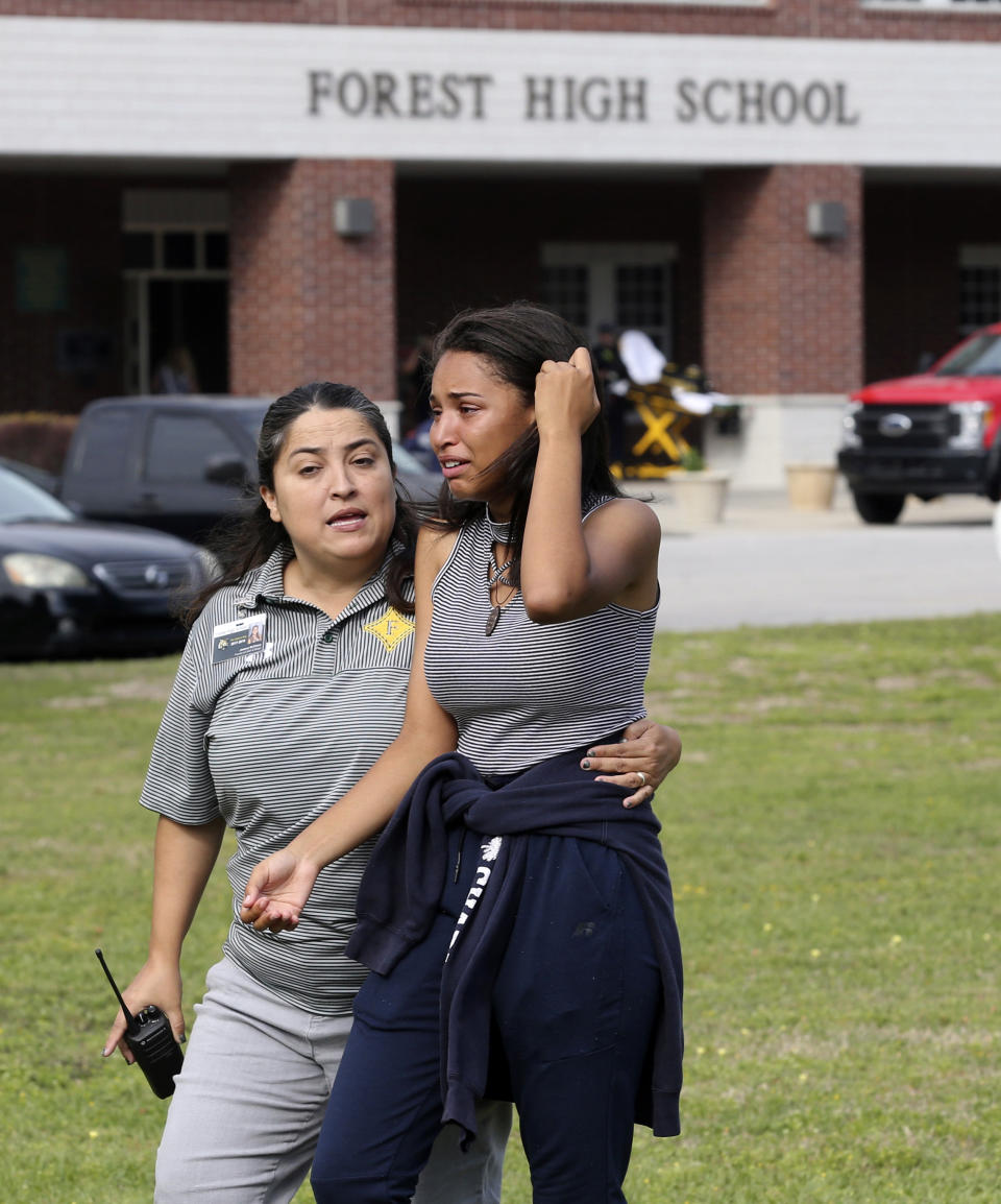 <p>A student is comforted by a school official as students are led out of Forest High School after a shooting at the school on Friday, April 20, 2018 in Ocala, Fla. (Photo: Bruce Ackerman/Star-Banner via AP) </p>