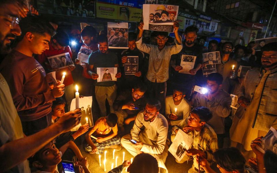 Kashmiri Shiite Muslims hold candles and photographs