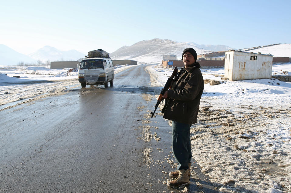 In this Thursday, Jan. 9, 2014 photo, Habibullah, an Afghan policeman stands guard at a check post in Kabul-Bamiyan road, on the outskirts of Maidan Shahr, capital of Wardak province Afghanistan. Locals call it "Death Road." The 30 kilometer (18 mile) stretch of road heading west from here has seen so many beheadings, kidnappings and other Taliban attacks in recent years that it's become a virtual no man's land, cutting off the Hazara minority from their homeland in Afghanistan's rugged mountainous center. (AP Photo/Massoud Hossaini)