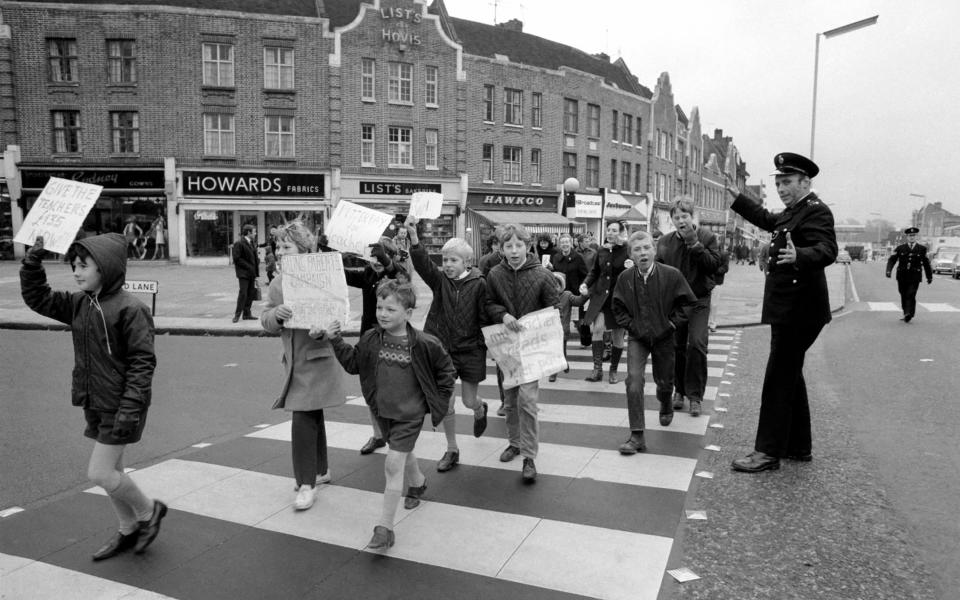 Industrial Disputes: Teachers Strike: All the schools in the Ealing area were closed for the day because of the teachers pay claim dispute. 7 year old Bily Fuller of Stanhope Junior School, Greenford, leads the demonstration down the Broadway with his sister Ann (12) OC Costain Senior Girls School, Greenford. December 1969 Z11596-006 (Photo by WATFORD/Mirrorpix/Mirrorpix via Getty Images)  - Getty