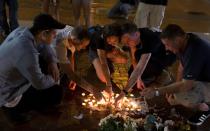 <p>People place candles as they gather during a vigil in Charlottesville, Virginia, USA, 12 August 2017. According to media reports at least one person was killed and 19 injured after a car hit a crowd of people counter-protesting the ‘Unite the Right’ rally which was scheduled to take place in Charlottesville on 12 August. At least 15 others were injured in clashes during protests. (Tasos Katopodis/EPA/REX/Shutterstock) </p>