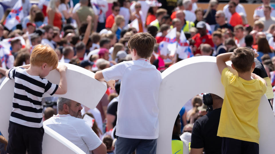 Three boys watching a crowd