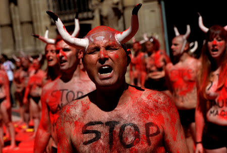 Animal rights protesters shout slogans after breaking mock banderillas containing red powder, which covered them during a demonstration for the abolition of bull runs and bullfights a day before the start of the famous running of the bulls San Fermin festival in Pamplona, northern Spain, July 5, 2017. REUTERS/Eloy Alonso