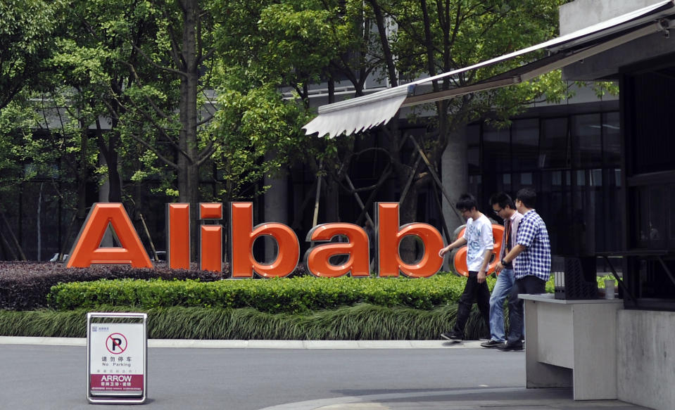 FILE - In this May 21, 2012 file photo, men walk past the corporate logo at the headquarters compound of Alibaba Group in Hangzhou in eastern China's Zhejiang province. Alibaba Group is aiming to raise $1 billion in a long-awaited IPO likely to have ripple effects across the Internet. The Tuesday, May 6, 2014 filing sets the stage for the technology industry's biggest initial public offering since short messaging service Twitter and its early investors collected $1.8 billion in its stock market debut last fall. (AP Photo/File) CHINA OUT