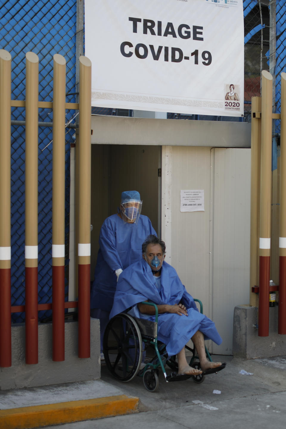 A medical worker moves a patient out of the COVID-19 triage area, at the Mexico General Hospital, in Mexico City, Tuesday, May 12, 2020. Mexican officials said Monday that more than 100 medical personnel have died from the novel coronavirus, while thousands have been infected. (AP Photo/Rebecca Blackwell)