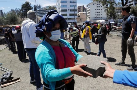 People clean debris from the streets in the aftermath of the last days' protests in Quito