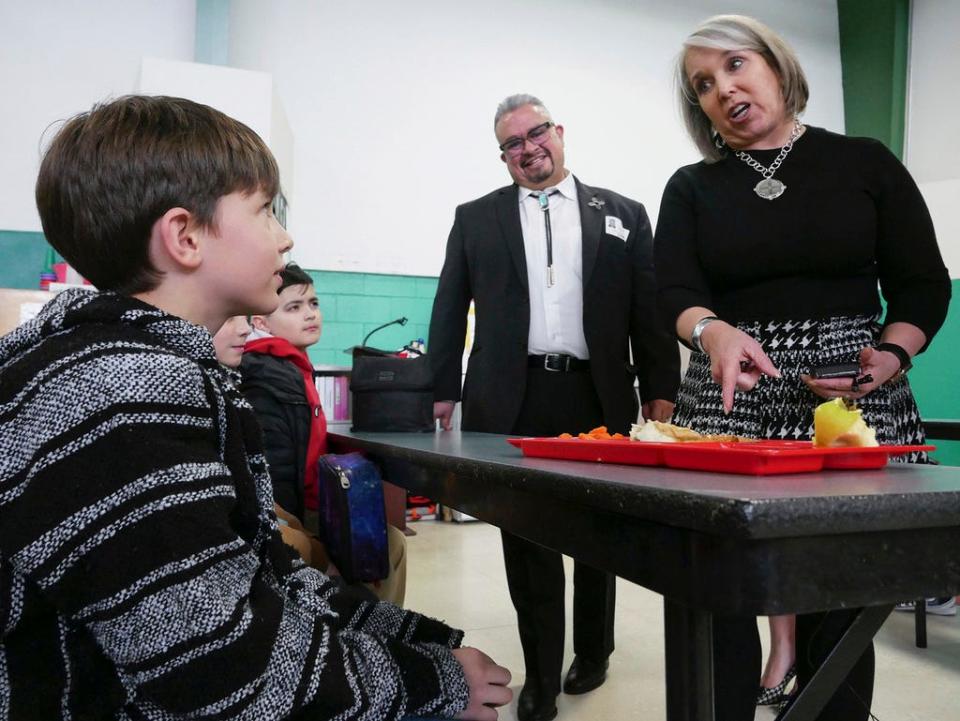 New Mexico Gov. Michelle Lujan Grisham, right, speaks to students at an elementary school in Santa Fe, N.M., Monday, March 27, 2023. The governor visited the school and signed legislation to provide free breakfast and lunch to all New Mexico students.