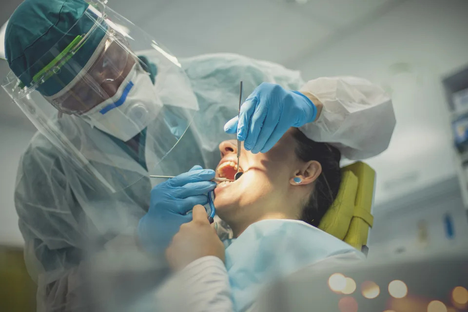 Dentist performing exam on woman