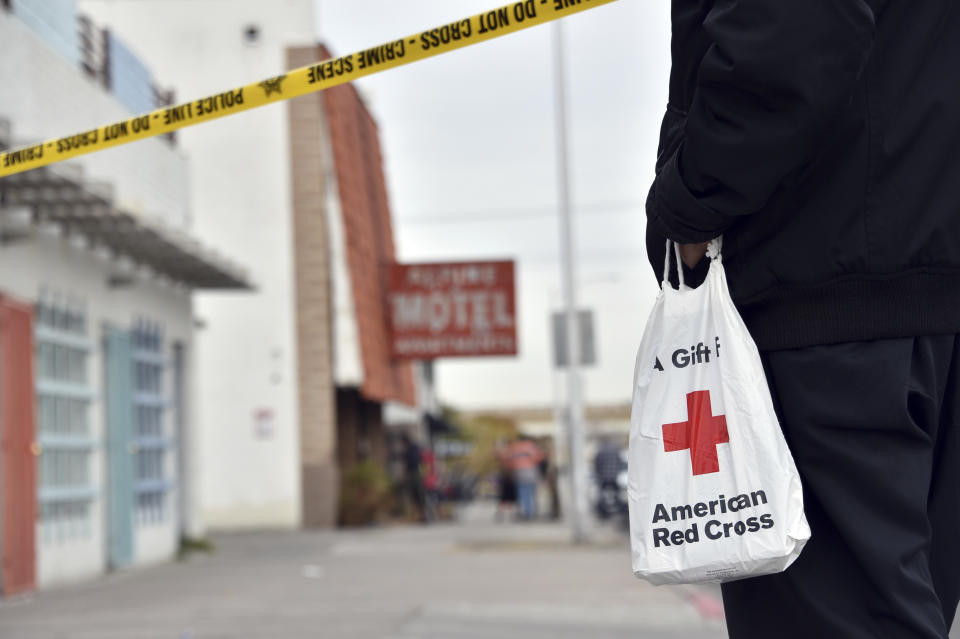 A displaced resident carries a bag from the Red Cross after a fire at a three-story apartment complex early Saturday, Dec. 21, 2019 in Las Vegas. The fire was in first-floor unit of the Alpine Motel Apartments and its cause was under investigation, the department said. Authorities say multiple fatalities were reported and many more were injured. (AP Photo/David Becker)