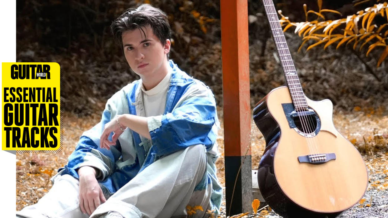  Marcin Patrzalek poses with an acoustic guitar. 