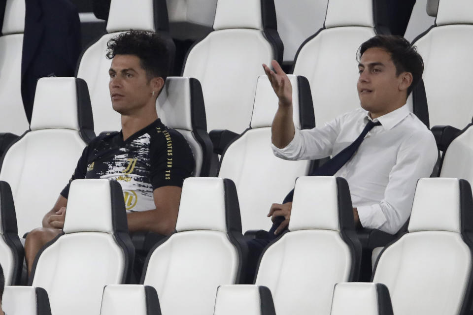 Juventus' Cristiano Ronaldo, left, and Juventus' Paulo Dybala gesture as attend a Serie A soccer match between Juventus and Roma, at the Allianz stadium in Turin, Italy, Saturday, Aug.1, 2020. (AP Photo/Luca Bruno)