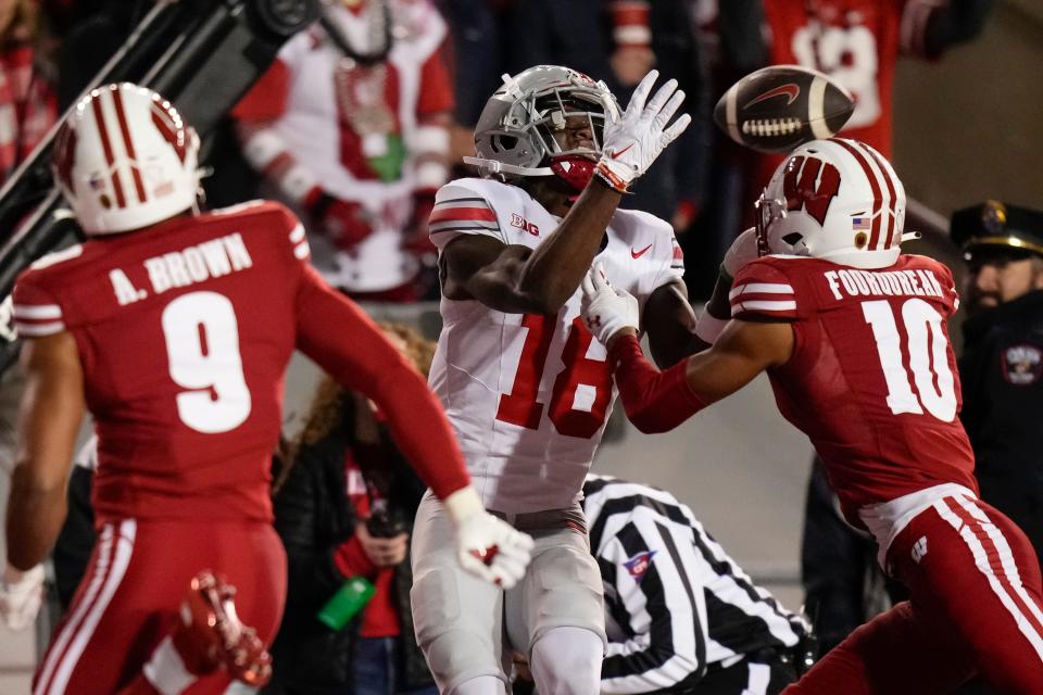 Oct 28, 2023; Madison, Wisconsin, USA; Ohio State Buckeyes wide receiver Marvin Harrison Jr. (18) catches a touchdown pass in front of Wisconsin Badgers cornerback Nyzier Fourqurean (10) during the second half of the NCAA football game at Camp Randall Stadium. Ohio State won 24-10.