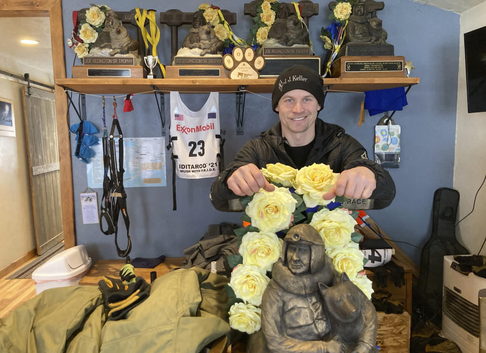 Dallas Seavey is shown Feb. 22, 2022, posing with his five Iditarod Trail Sled Dog championship trophies in Talkeetna, Alaska. Seavey is tied with musher Rick Swenson for the most Iditarod victories ever at five, and Seavey is looking for his sixth title when the Iditarod Trail Sled Dog Race starts this weekend in Alaska. (AP Photo/Mark Thiessen)