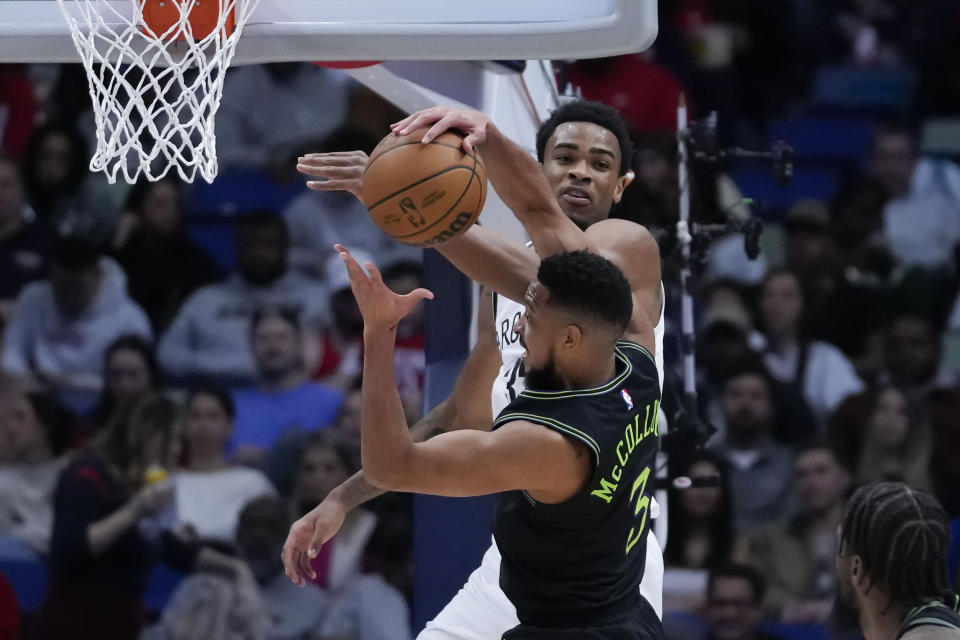 New Orleans Pelicans guard CJ McCollum (3) goes to the basket against Brooklyn Nets center Nic Claxton in the first half of an NBA basketball game in New Orleans, Tuesday, Jan. 2, 2024. (AP Photo/Gerald Herbert)