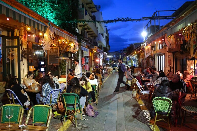 La gente come en un restaurante en la ciudad costera israelí de Tel Aviv el 7 de marzo de 2021, después de que las autoridades reabrieran restaurantes, bares y cafés a los titulares de "pases verdes" vacunados