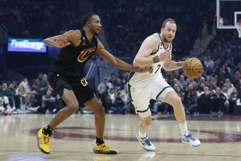 Milwaukee Bucks guard Joe Ingles (7) drives against Cleveland Cavaliers forward Evan Mobley during the first half of an NBA basketball game, Saturday, Jan. 21, 2023, in Cleveland. (AP Photo/Ron Schwane)