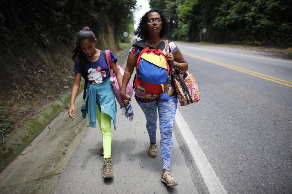 En esta imagen, tomada el 2 de septiembre de 2018, la venezolana Sandra Cádiz agarra la mano de su hija Angelis, de 10 años, mientras caminas por el arcén de una carretera en su viaje a Perú, cerca de Dagota, Colombia. Cuando Cádiz comenzó a tener problemas para alimentar a su hija supo que era el momento de salir de Venezuela. (AP Foto/Ariana Cubillos)