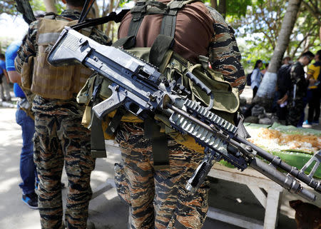 An assault weapon is pictured while a Filipino soldier eats a meal in Philippine occupied Thitu Island on Spratly Islands in disputed South China Sea, April 21, 2017. REUTERS/Erik De Castro