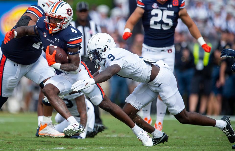 Auburn Tigers running back Tank Bigsby (4) tries to elude Penn State Nittany Lions defensive back Joey Porter Jr. (9) as Auburn Tigers take on Penn State Nittany Lions at Jordan-Hare Stadium in Auburn, Ala., on Saturday, Sept. 17, 2022.