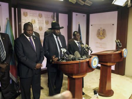 South Sudan President Salva Kiir (C), flanked by former rebel leader Riek Machar (L) and other government officials, addresses a news conference at the Presidential State House in Juba, South Sudan, July 8, 2016. REUTERS/Stringer