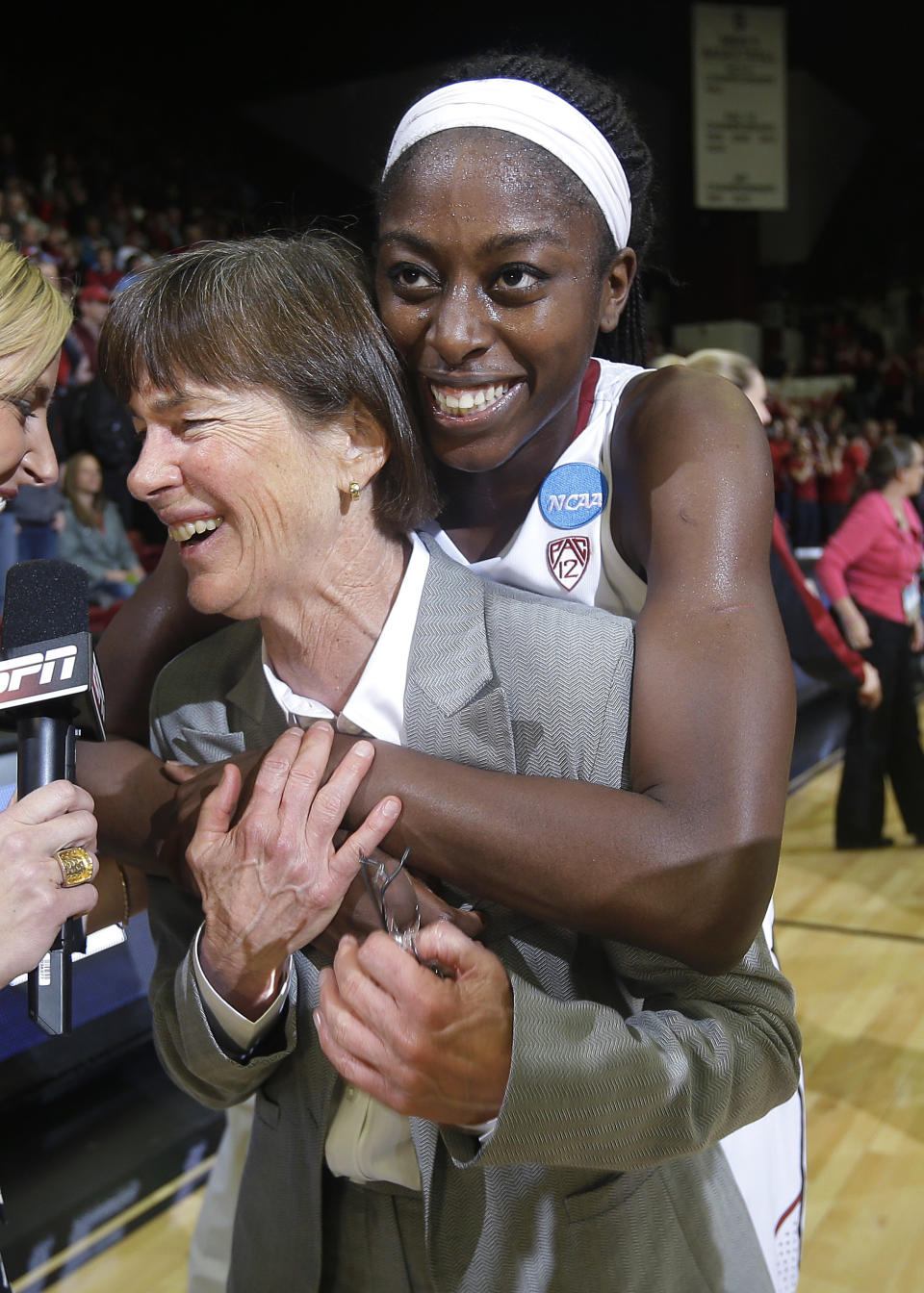 Stanford coach Tara VanDerveer is hugged by forward Chiney Ogwumike, rear, during an interview after a regional final against North Carolina in the NCAA women's college basketball tournament in Stanford, Calif., Tuesday, April 1, 2014. Stanford won 74-65. (AP Photo/Marcio Jose Sanchez)