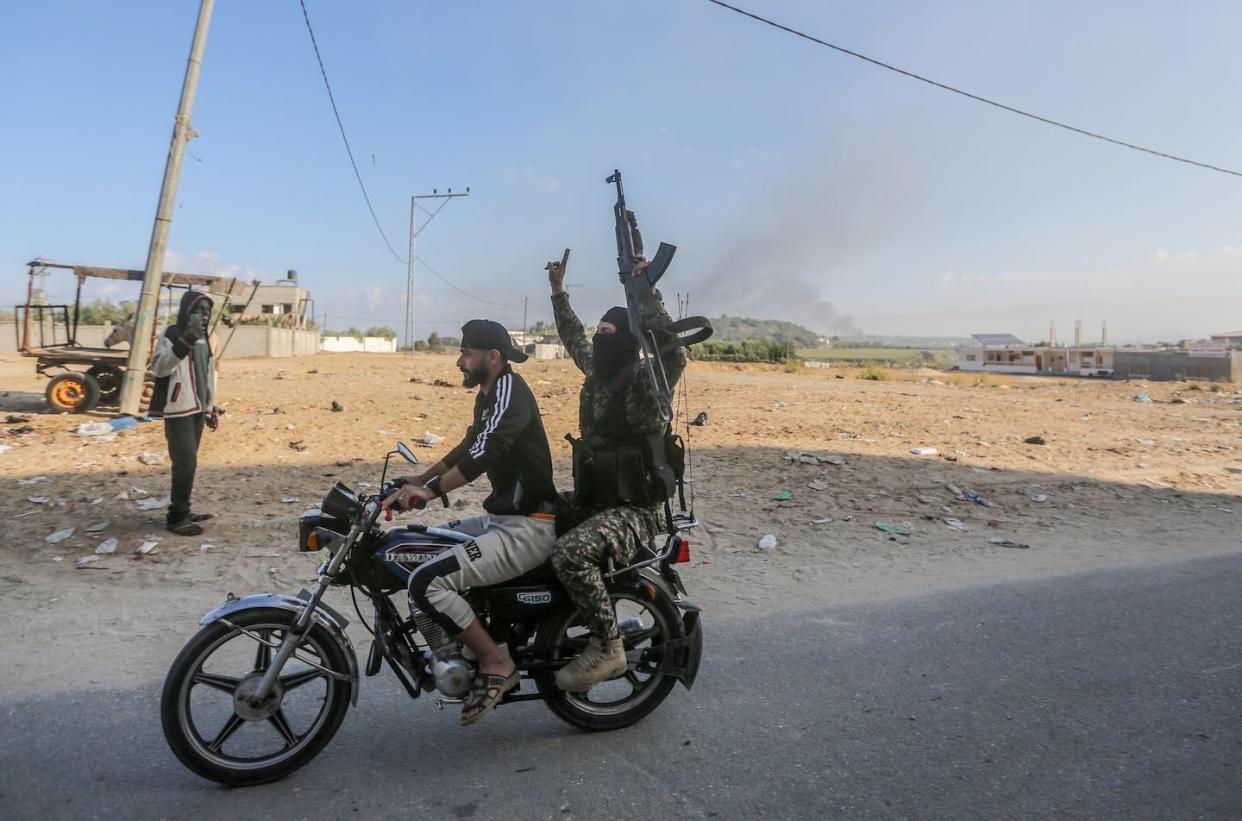 A Palestinian militant rides on the back of a motorcycle near a crossing between Israel and the northern Gaza Strip on Oct. 7, 2023. <a href="https://www.gettyimages.com/detail/news-photo/palestinians-at-the-erez-crossing-also-known-as-the-beit-news-photo/1713407740" rel="nofollow noopener" target="_blank" data-ylk="slk:Ahmed Zakot/SOPA Images/LightRocket via Getty Images;elm:context_link;itc:0;sec:content-canvas" class="link ">Ahmed Zakot/SOPA Images/LightRocket via Getty Images</a>