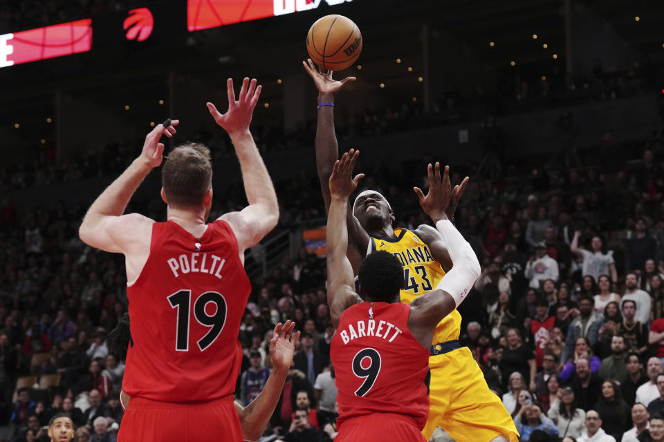 Indiana Pacers forward Pascal Siakam (43) scores over Toronto Raptors guard RJ Barrett (9) as center Jakob Poeltl (19) looks on during the second half of an NBA basketball game Wednesday, Feb. 14, 2024, in Toronto. (Chris Young/The Canadian Press via AP)