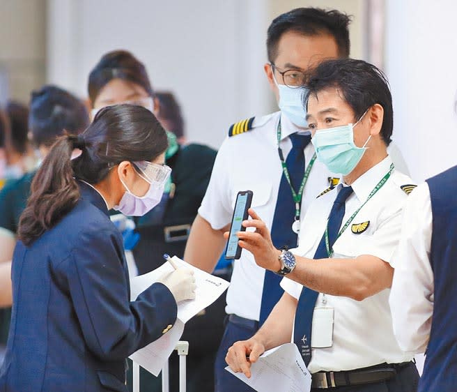 圖為在桃園機場入境管制區內，結束飛行任務的機組員排隊查驗入境健康資料。（圖：范揚光）