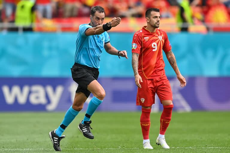 El árbitro argentino Fernando Rapallini gesticula junto al delantero de Macedonia del Norte Aleksandar Trajkovski durante el partido de fútbol del Grupo C de la UEFA EURO 2020 entre Ucrania y Macedonia del Norte