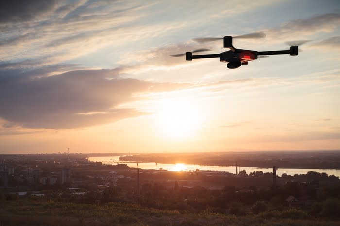 Quadcopter drone set against a sunrise scene