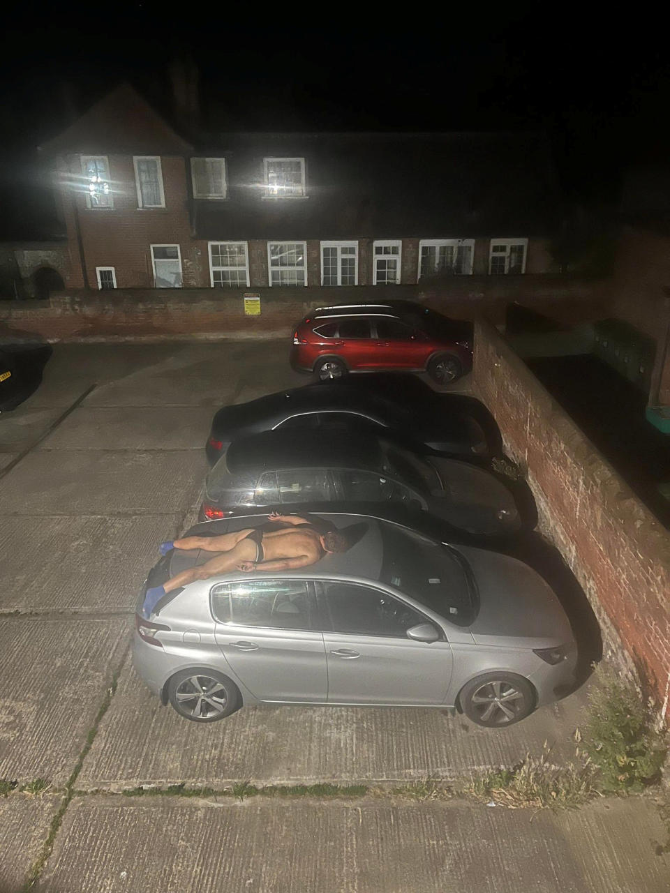 A resident was stunned to spot an apparently drunk man wearing just socks and pants asleep - on the top of a car. See SWNS story SWLNcar; Tom Selby heard a commotion in the night thought badgers had been creating the noise on Sunday (14/08) morning. mBut when he checked his CCTV he saw a man wearing only his socks and pants fast asleep on top of his car outside. Tom, of Cromer, Norfolk, described himself as a 
