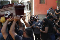 FILE - In this Sept. 22, 2020, file photo, relatives of Tranquilino Ruiz Cabrera, who worked as a taxi driver and died from COVID-19 related complications, mourn during his burial at Asuncions's Recoleta Cemetery, in Paraguay. The worldwide death toll from the coronavirus eclipsed 1 million, nine months into a crisis that has devastated the global economy, tested world leaders' resolve, pitted science against politics and forced multitudes to change the way they live, learn and work. (AP Photo/Jorge Saenz, File)