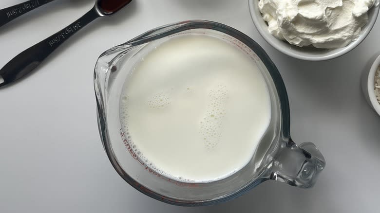 a glass measuring cup of milk 