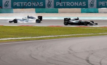 Formula One - F1 - Malaysia Grand Prix - Sepang, Malaysia - 2/10/16 Mercedes' Nico Rosberg of Germany (L) crashes next to Mercedes' Lewis Hamilton of Britain during the race. REUTERS/Edgar Su