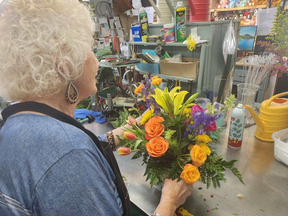 Mary Ruth Albracht, owner of Scotts Flower's, prepares finishing touches on a bouquet in preparation for Mother's Day as orders begin to flood in.