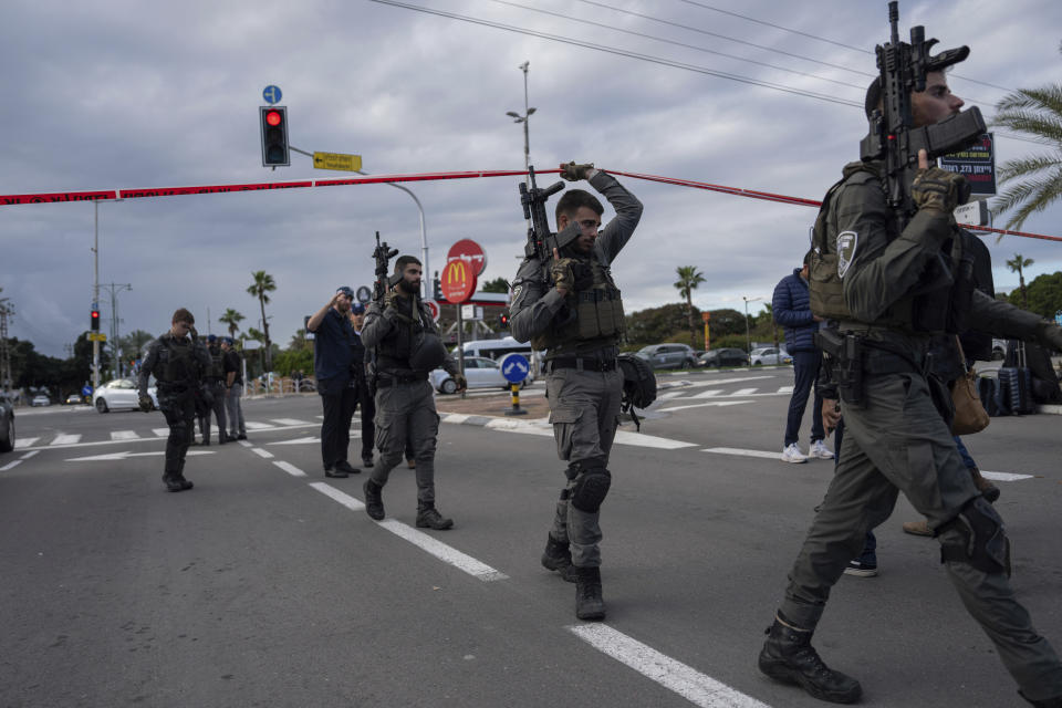 Israeli security forces search for assailants near the scene of a deadly car-ramming and stabbing attack at a bus stop, in Ra'anana, Israel, Monday, Jan. 15, 2024. Israeli police say a car-ramming and stabbing attack by Palestinians killed a woman and wounded at least 12 others north of Tel Aviv. The police say they arrested two Palestinian suspects from the West Bank. They say the suspects stole three different cars and attempted to run down pedestrians. (AP Photo/Oded Balilty)