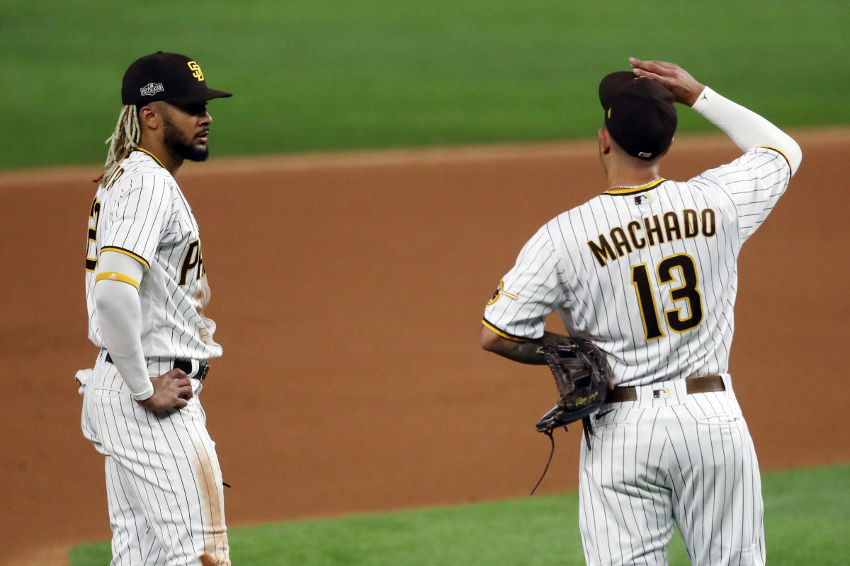 San Diego Padres' Manny Machado, right, slides into to third past