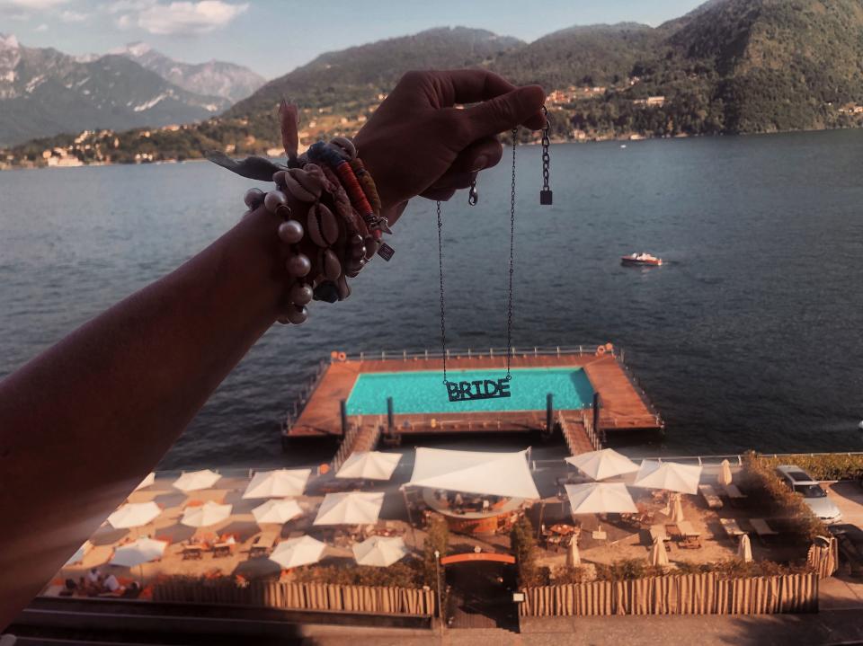 Birds-eye shot of the floating beach from our room at Grand Hotel Tremezzo. Holding a Dannijo “Bride” necklace.