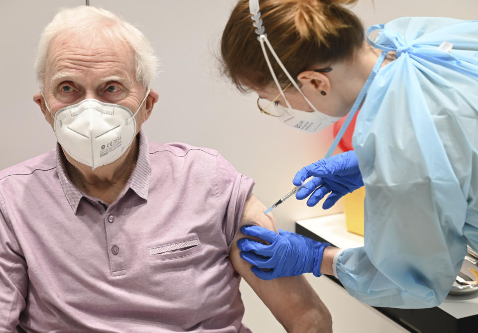 Richard Kilian from Wiesbaden-Schierstein is vaccinated with the Biontech/Pfizer vaccine by Fenna Martin at the vaccination center in the RMCC convention center in Wiesbbaden, Germany, Tuesday, Jan.19, 202. (Arne Dedert/dpa via AP)