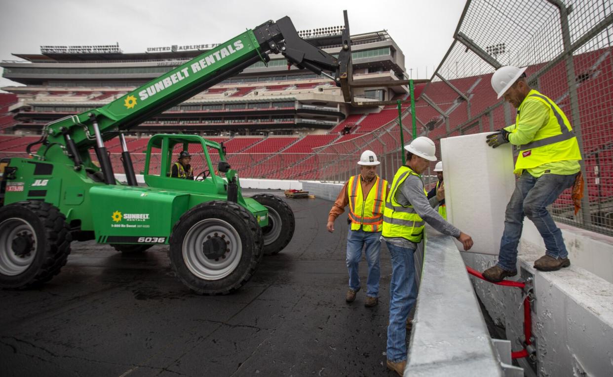 Terry Swinford, Larry Knowles, and Earl Creach install a section of the SAFER barrier around the race track.