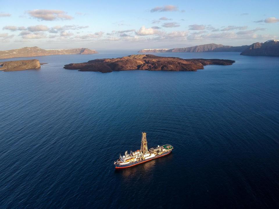 aerial view of the ship on the blue sea with the islands in the background