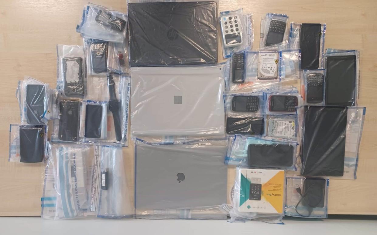 Laptops, mobile phones and other devices are seized by police