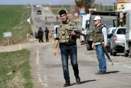 Security officers stand guard near the site where a military vehicle was damaged by a remote control bomb, near Diyarbakir, Turkey February 18, 2016. A bomb detonated by remote control killed seven Turkish security force members travelling in a military vehicle in southeast Turkey on Thursday, security sources said, a day after a car bomb attack in the capital Ankara killed 28 people. REUTERS/Sertac Kayar