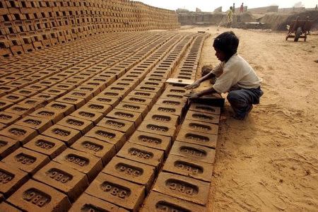 An Indian Child makes bricks at a brick kiln unit near Bahadurgarh in Haryana, December 30, 2005. REUTERS/Kamal Kishore/Files