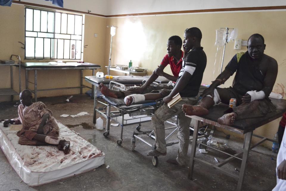 FILE- In this Monday, Sept. 21, 2015 file photo, Victims receive treatment at a hospital, after an explosion in Maiduguri, Nigeria. Nigerian President Muhammadu Buhari's nearly month-long medical leave in London is reminding his country's taxpayers that while they finance their leaders' health care abroad, they often are stuck with decrepit, ill-staffed government health facilities at home. (AP Photo/Jossy Ola File)