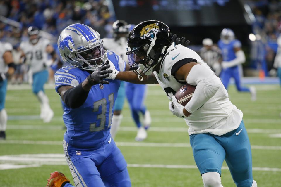 Jacksonville Jaguars wide receiver Christian Kirk stiff arms Detroit Lions safety Kerby Joseph (31) during the first half of an NFL football game, Sunday, Dec. 4, 2022, in Detroit. (AP Photo/Duane Burleson)