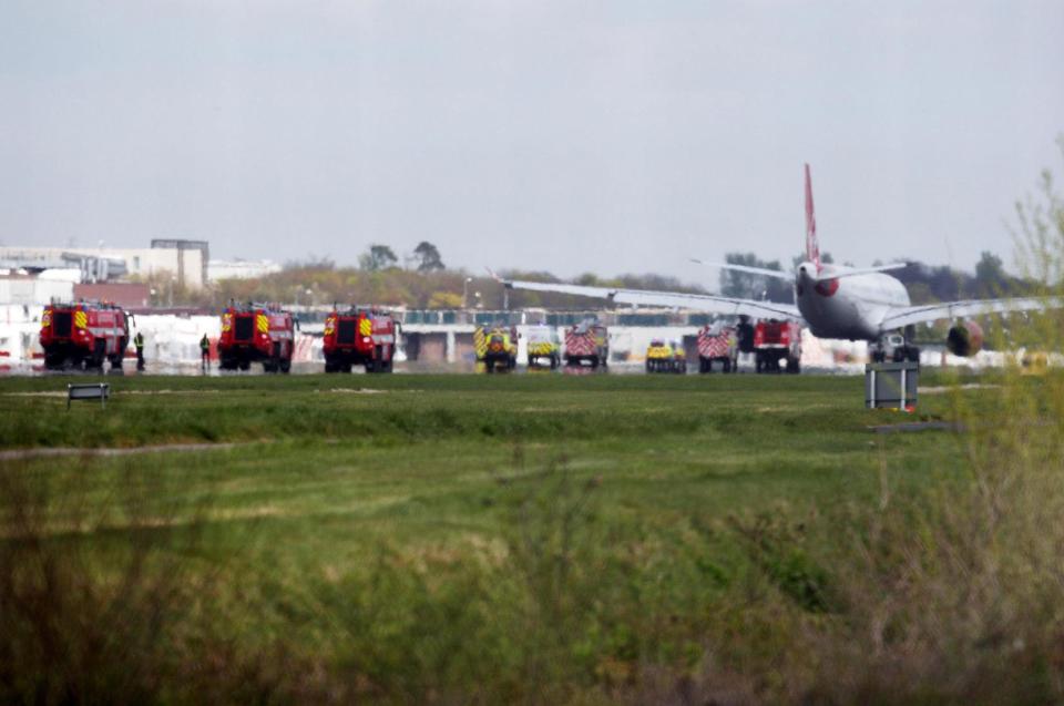 A Virgin Atlantic Airbus A330 aircraft is towed away from the runway at Gatwick Airport, England after it was forced to return and make an emergency landing Monday April 16, 2012. Virgin Atlantic said four people suffered minor injuries after a plane bound from Britain to Florida made an emergency landing at London's Gatwick Airport on Monday. The airline said that all passengers and crew have safely disembarked the plane, but declined to provide further details on the nature of the injuries, who was affected or what caused the emergency landing.(AP Photo/Steve Parsons/PA) UNITED KINGDOM OUT
